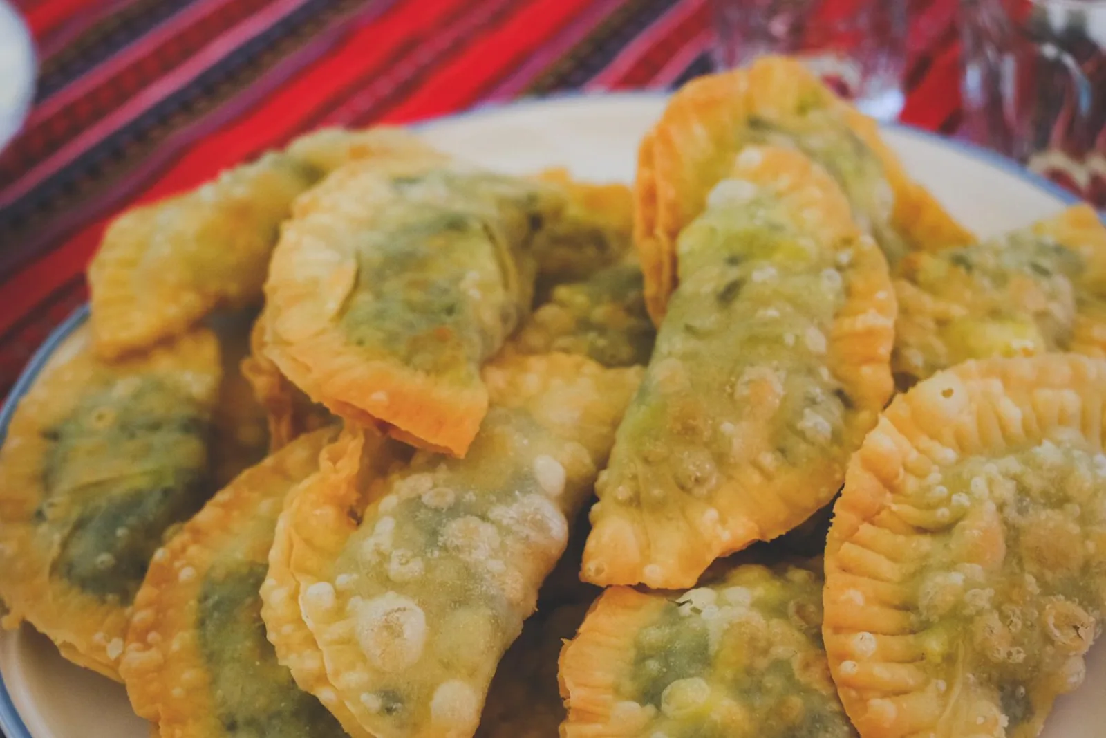 A plate of golden fried kalitsounia, small Cretan pies filled with cheese and wild greens