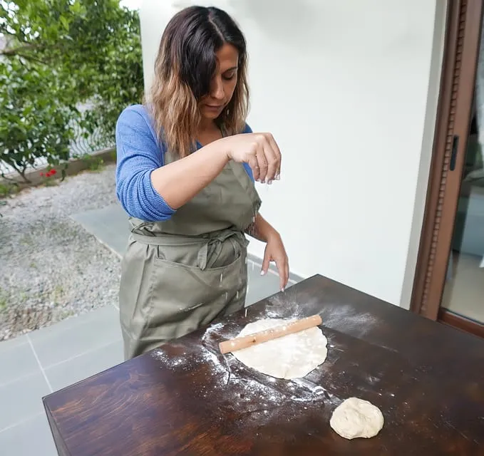Rolling out pastry dough on a floured wooden table