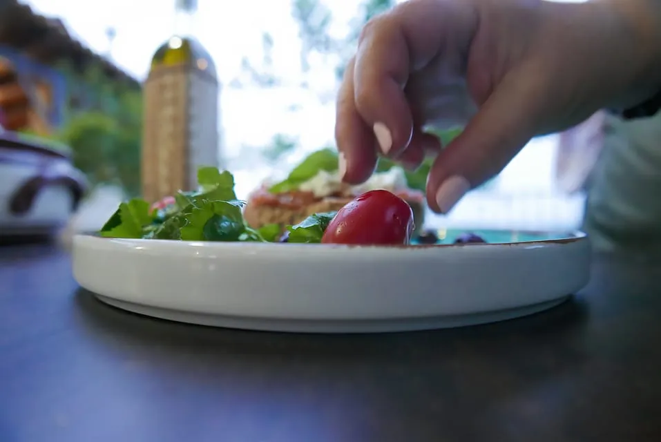A finished plate being garnished at the table
