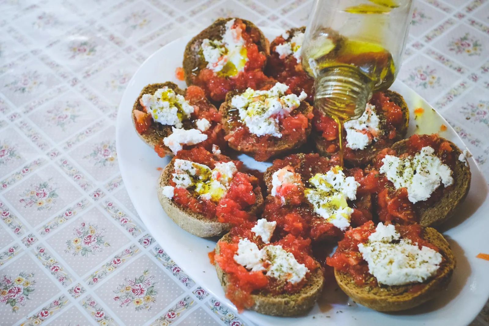 A plate of dakos — barley rusks topped with grated tomato, soft mizithra cheese and olive oil